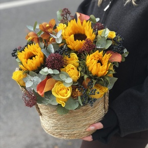 Композиция в сумке "Тональность" из подсолнухов, калл, ягод вибирнума, лимонных роз, скиммии и орхидеи в Бронницах